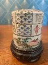 Très jolie boîte de Chine, en porcelaine et forme tube à décor de montagnes, de paysages et de formes géométriques. Boîte à couvert sur son socle en bois noirci elle est  en bon état peinte à la main bien sur. Elle mesure 10cm de haut pour 6 de diamètre socle compris, qui ne s'enlève pas.                                          Very pretty Chinese box, in porcelain and tube shape decorated with mountains, landscapes and geometric shapes. Cutlery box on its blackened wooden base, it is in good condition, hand-painted of course. It measures 10cm high by 6 in diameter including the base, which cannot be removed.