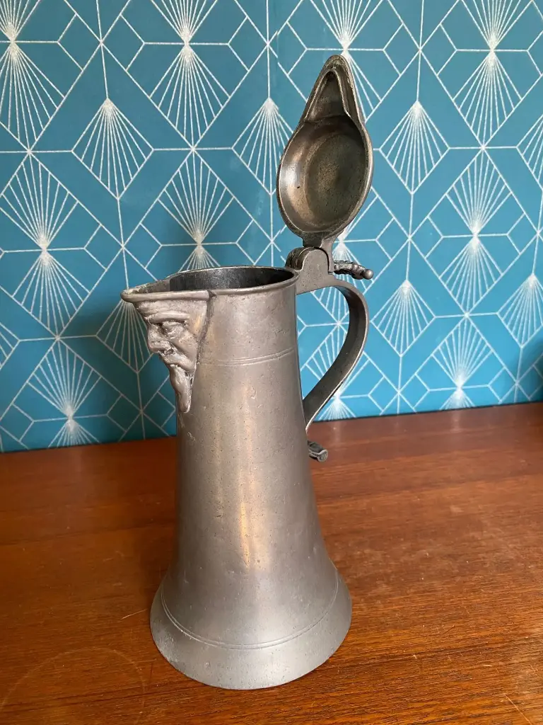 Chope en étain, XVIIIème, à décors d'un visage, armoiries présentes. Rare.  Pewter tankard, 18th century, decorated with a face, coat of arms present. Rare.