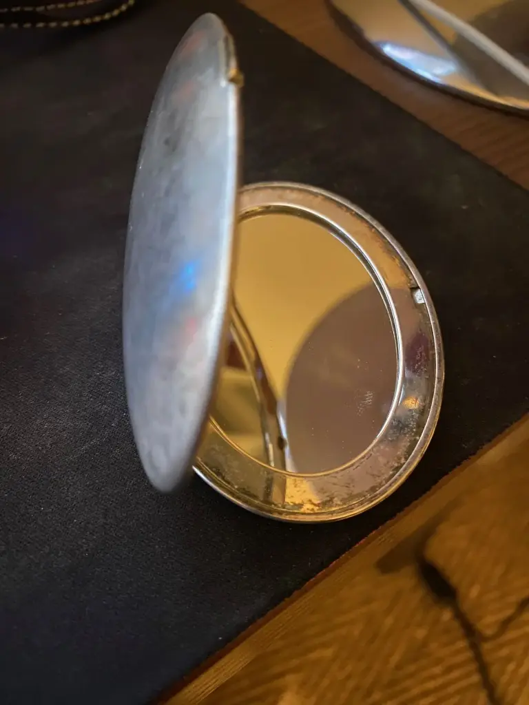 Miroir de poche signé Laurent Perrier, métal brossé, objet publicité champagne.                                            Pocket mirror signed Laurent Perrier, brushed metal, champagne advertising object.